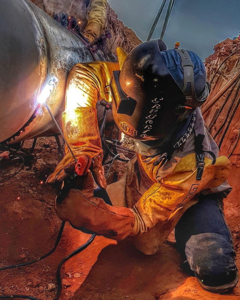 Un soudeur à l'arc sur un pipe.